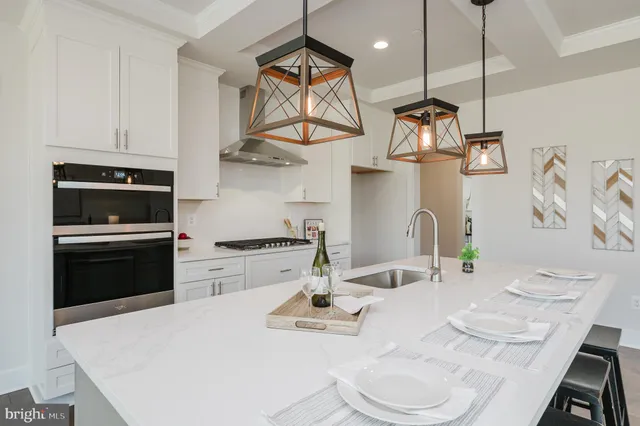 a view of a kitchen with kitchen island a sink a stove and a wooden floor