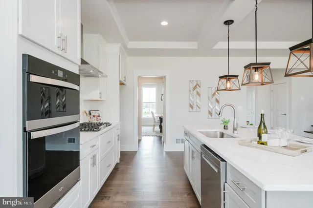 a kitchen with a sink dishwasher and a dining table with wooden floor
