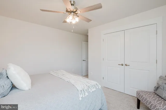a bedroom with a bed and a ceiling fan