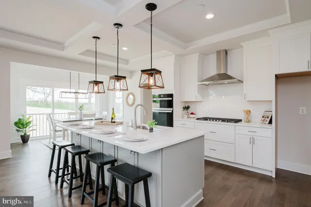 a kitchen with stainless steel appliances granite countertop a stove a sink dishwasher and a refrigerator with wooden floor