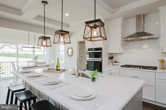 a kitchen with stainless steel appliances wooden floor dining table and chairs