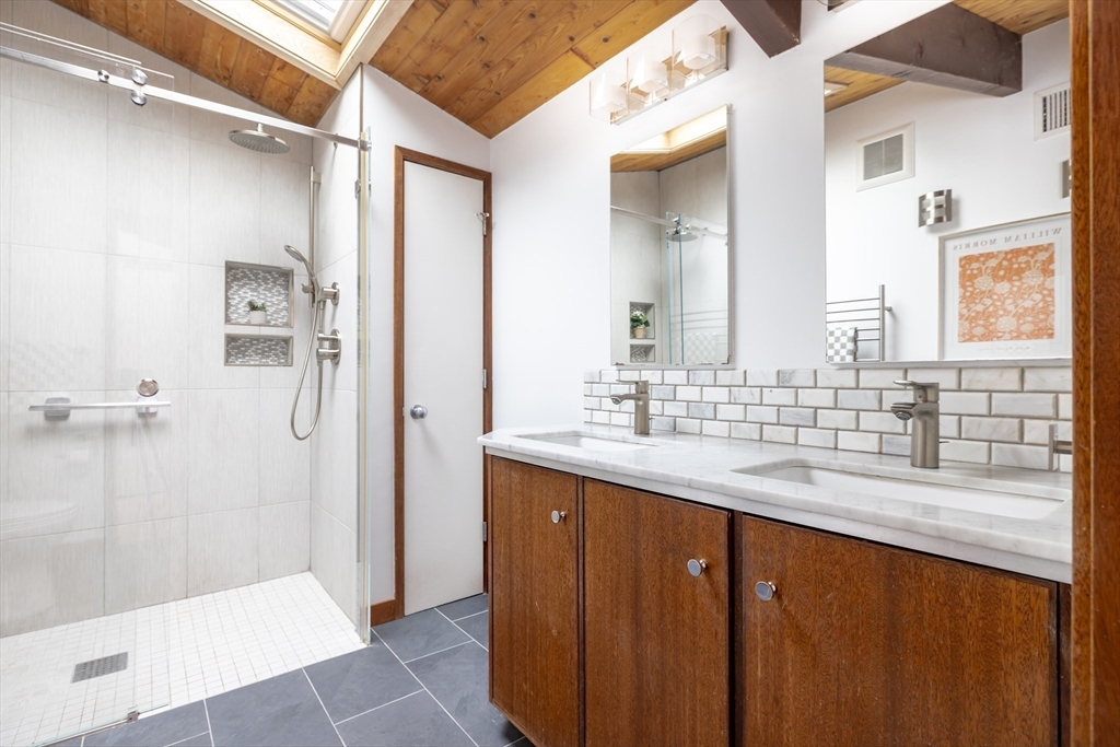 134 Rangeley Road Brookline, MA 02467 - Photo 14 of 27 a bathroom with a granite countertop sink a mirror and a bathtub