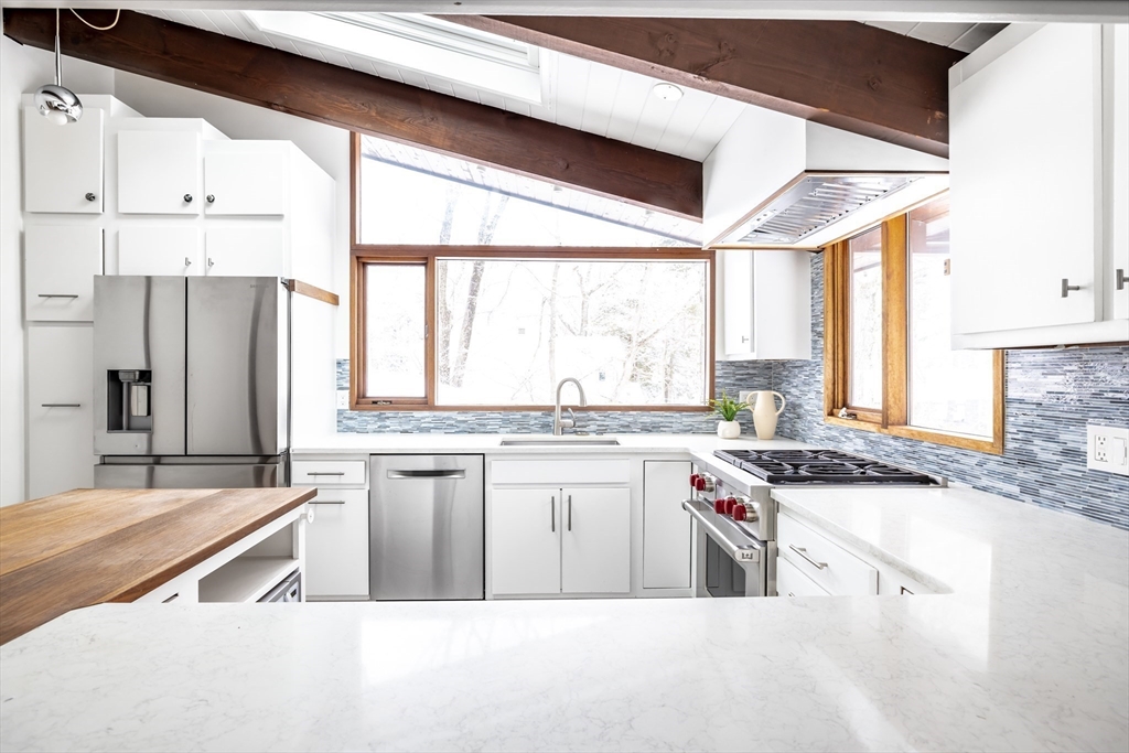 134 Rangeley Road Brookline, MA 02467 - Photo 5 of 27 a kitchen with stainless steel appliances granite countertop a stove a sink and a refrigerator
