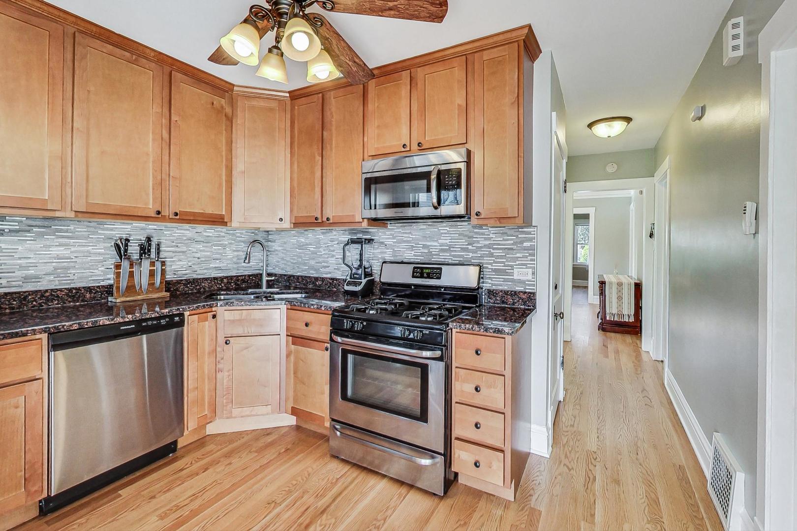 1434 Elgin Avenue Forest Park, IL 60130 - Photo 12 of 35 a kitchen with stainless steel appliances granite countertop a stove and a sink
