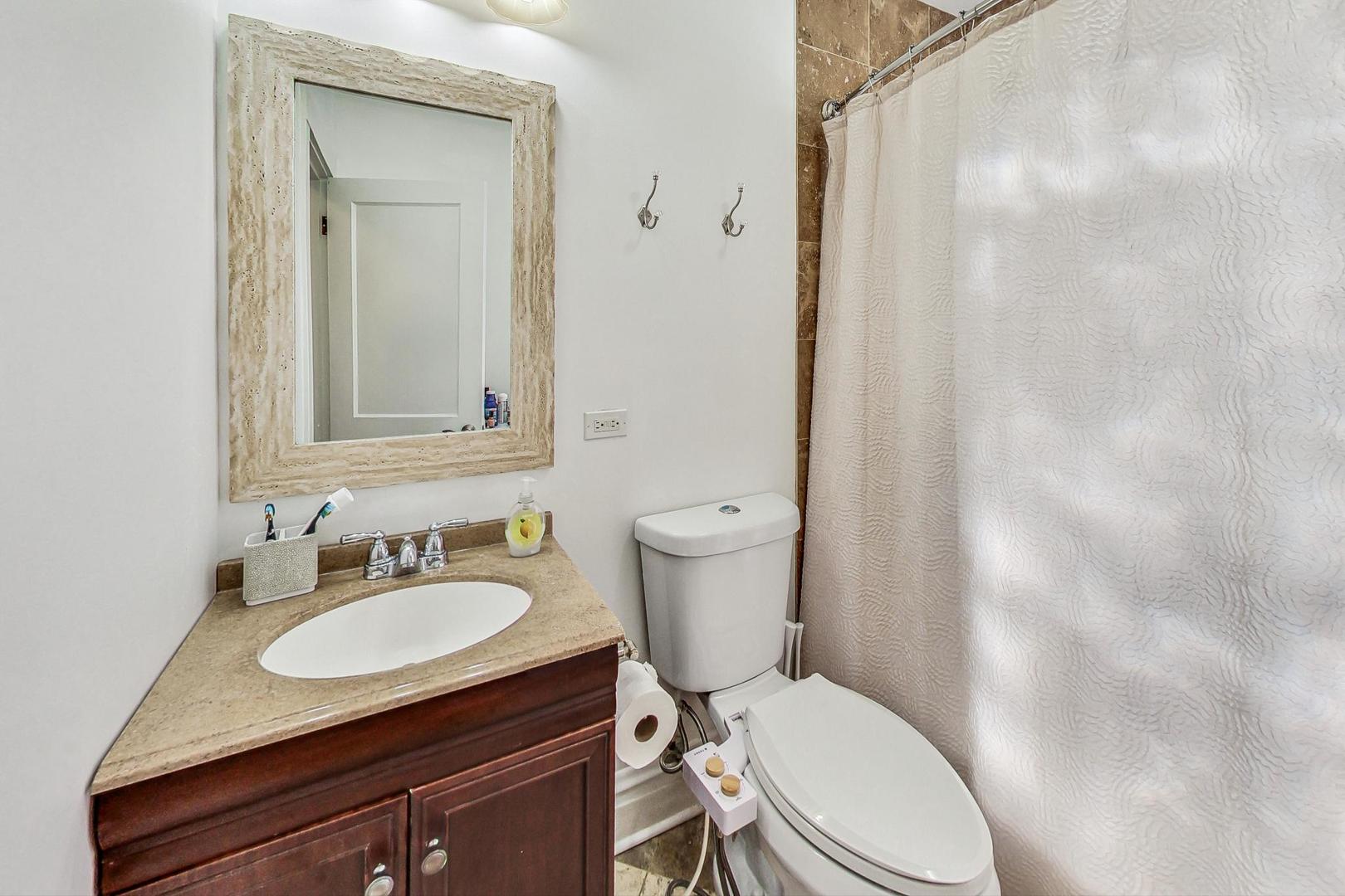 1434 Elgin Avenue Forest Park, IL 60130 - Photo 20 of 35 a bathroom with a granite countertop toilet sink and mirror