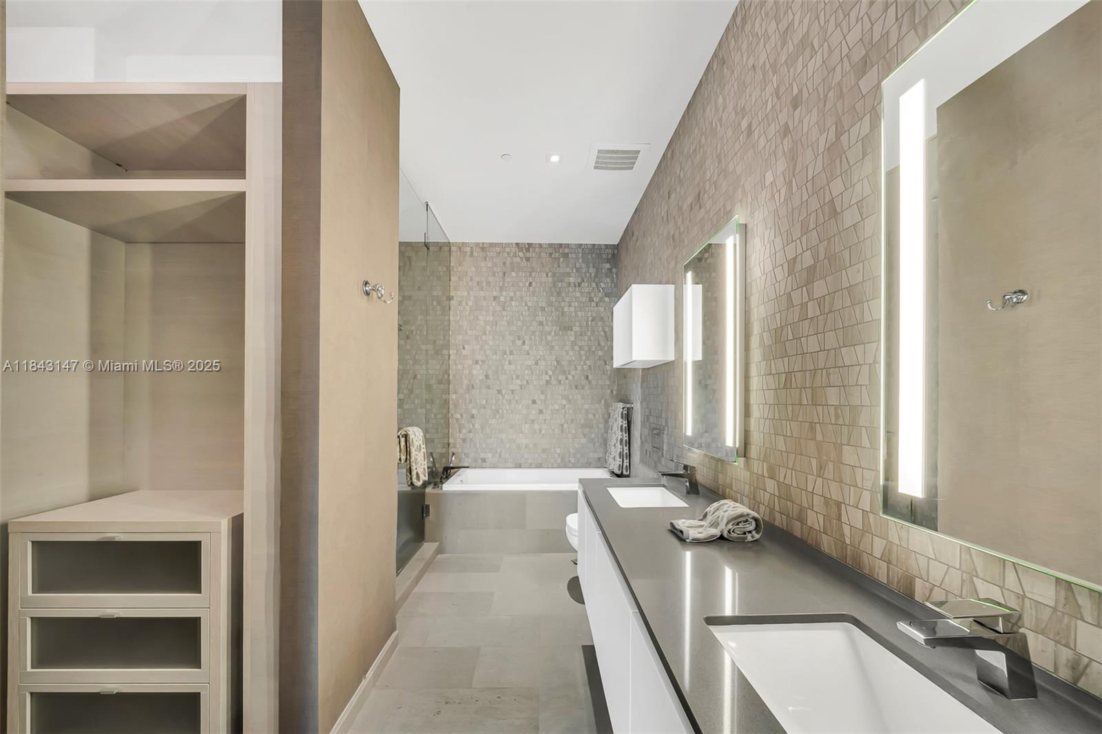 88 Southwest 7th Street, Unit 4006 Miami, FL 33130 - Photo 13 of 22 a large bathroom with a tub sink and mirror