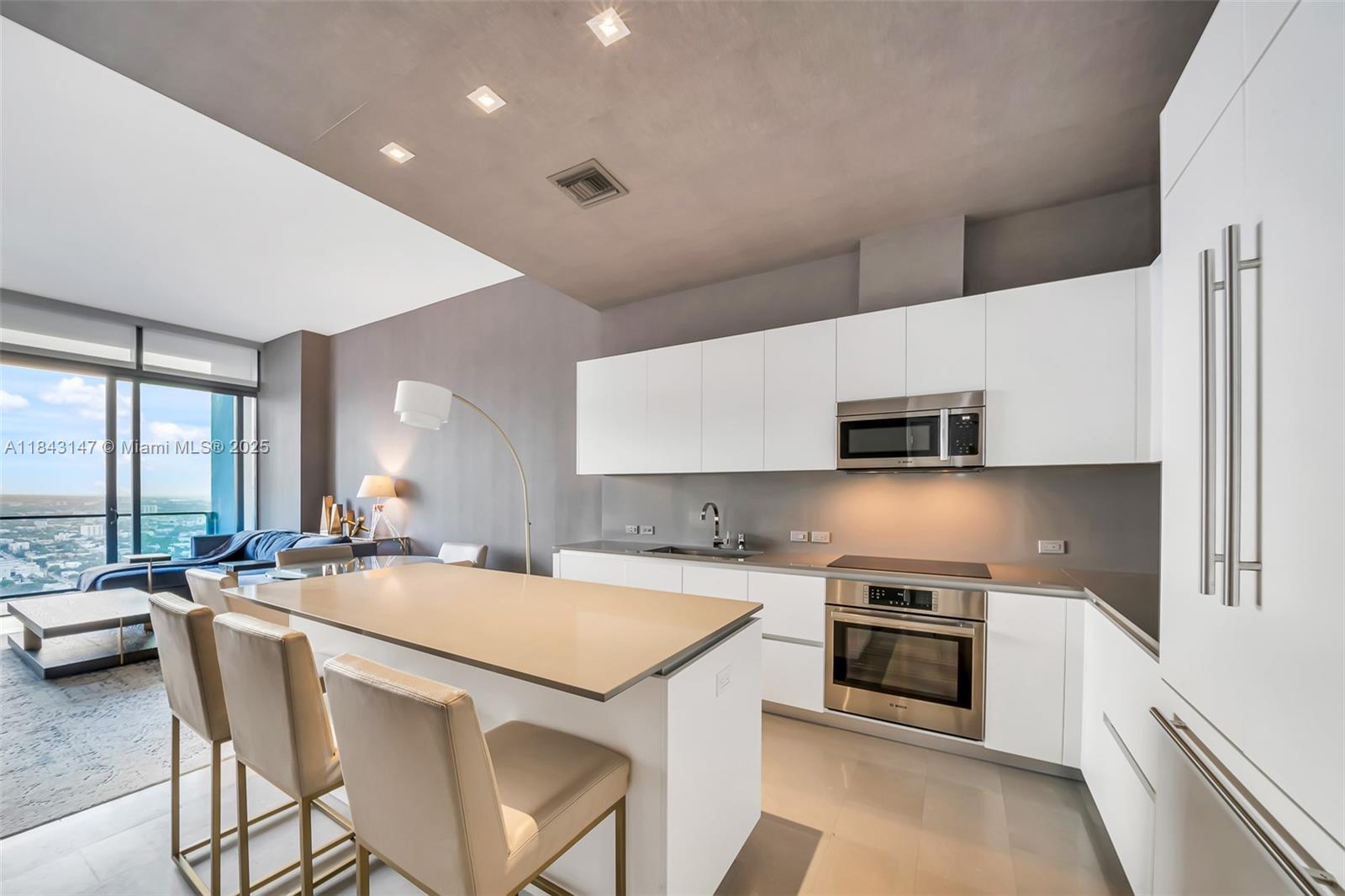 88 Southwest 7th Street, Unit 4006 Miami, FL 33130 - Photo 8 of 22 a kitchen with stainless steel appliances a stove a sink a microwave a refrigerator and cabinets