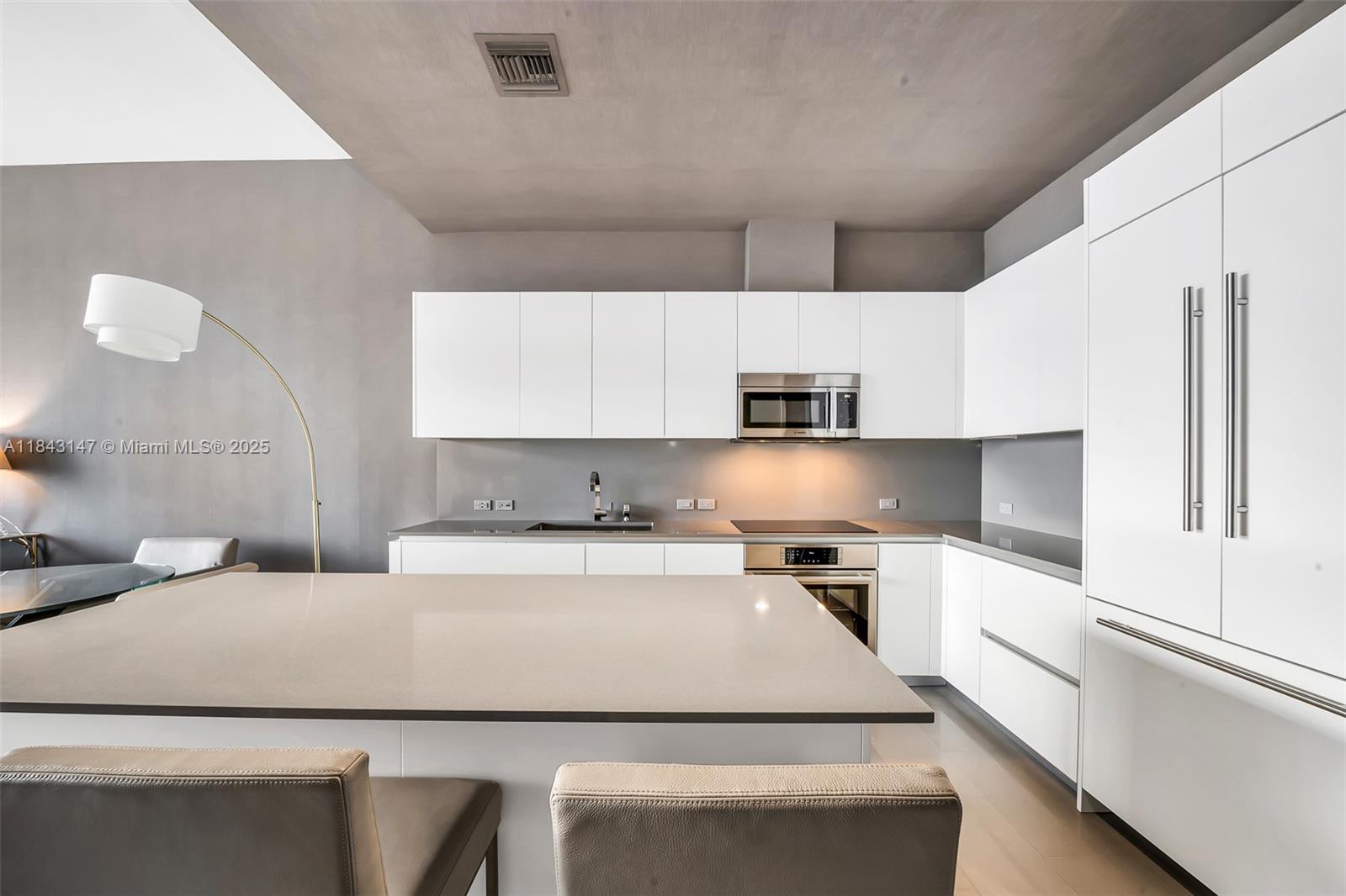 88 Southwest 7th Street, Unit 4006 Miami, FL 33130 - Photo 10 of 22 a kitchen with a sink a stove and white cabinets