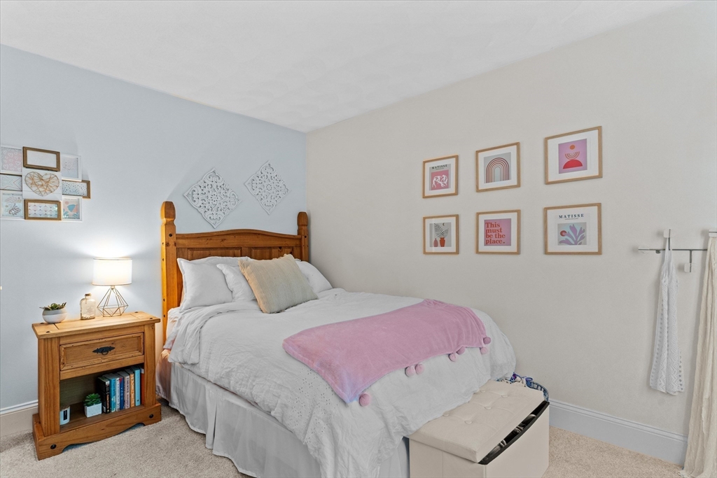 69 Curzon Mill Road Newburyport, MA 01950 - Photo 30 of 40 a bedroom with a bed and a fireplace