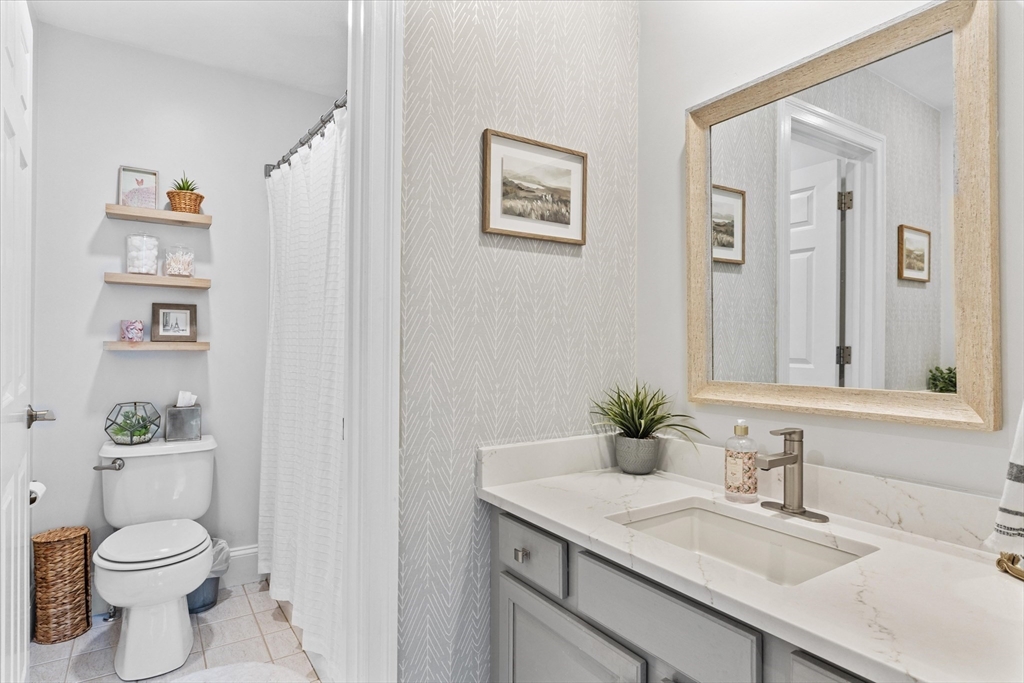 69 Curzon Mill Road Newburyport, MA 01950 - Photo 32 of 40 a bathroom with a granite countertop sink mirror and toilet