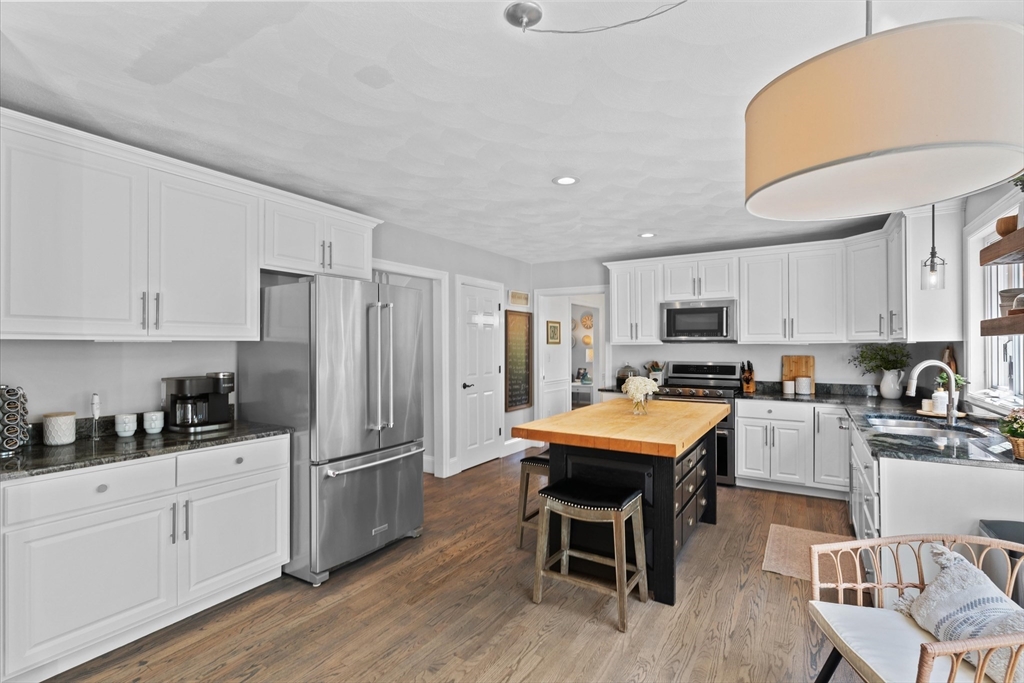 69 Curzon Mill Road Newburyport, MA 01950 - Photo 6 of 40 a kitchen with stainless steel appliances kitchen island granite countertop a refrigerator a stove a sink dishwasher and white cabinets with wooden floor