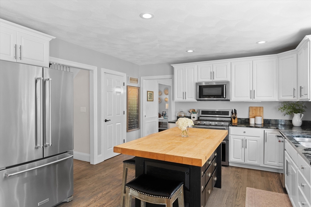 69 Curzon Mill Road Newburyport, MA 01950 - Photo 7 of 40 a kitchen with stainless steel appliances a stove a refrigerator a sink and white cabinets with wooden floor