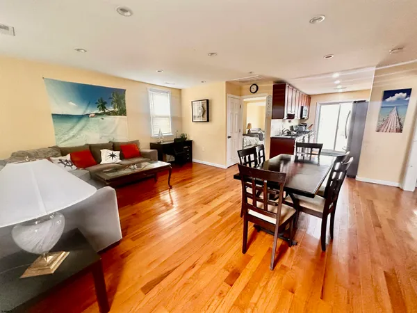 a dining room with wooden floor and large window