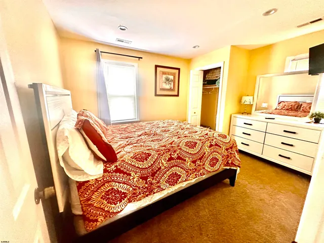 a spacious bedroom with a bed and wooden floor