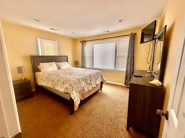a bedroom with a bed window and a dresser