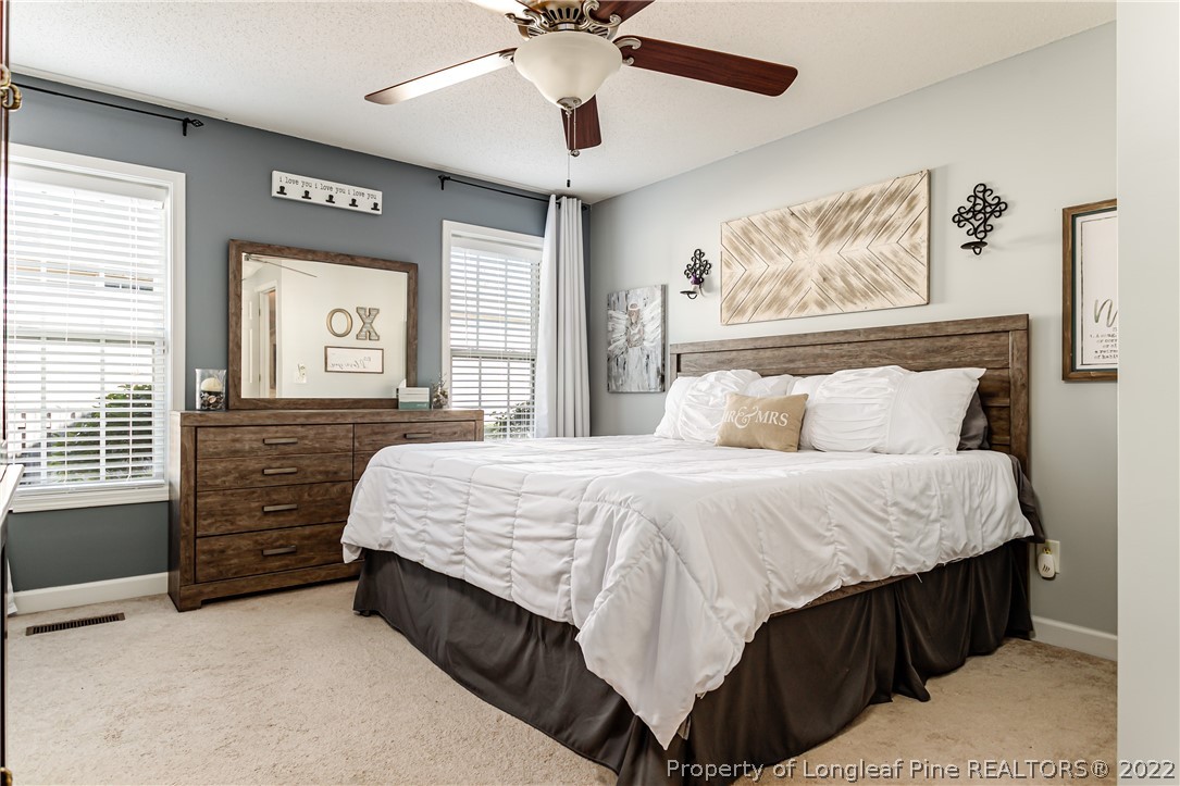 23 Beryl Circle Pinehurst, NC 28374 - Photo 15 of 29 a bedroom with a bed and a chandelier