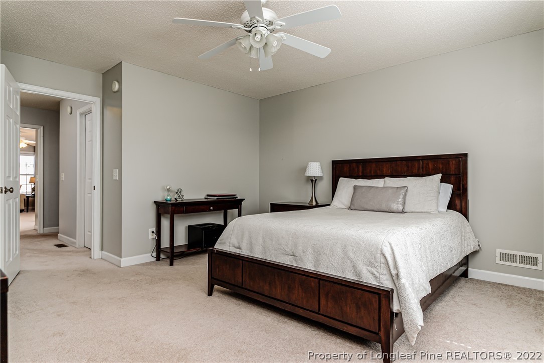 23 Beryl Circle Pinehurst, NC 28374 - Photo 23 of 29 a bedroom with a bed and a chandelier