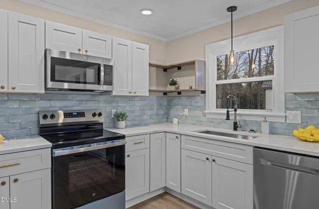 a open kitchen with white cabinets and wooden floor