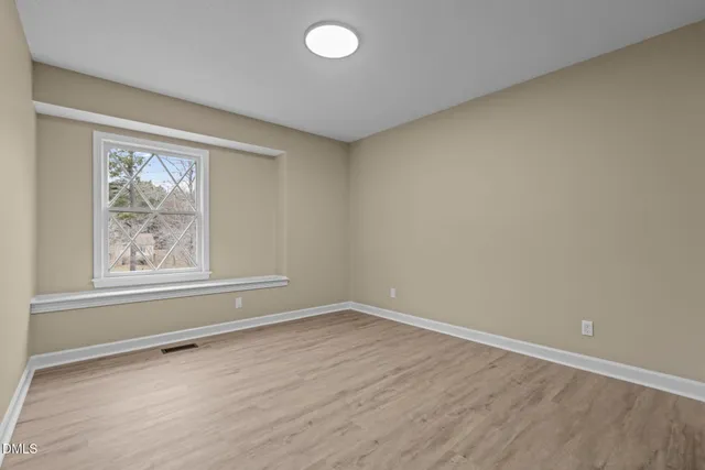 a view of an empty room with wooden floor