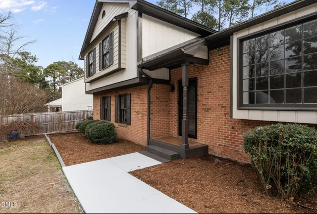 a view of a house with backyard and a tree