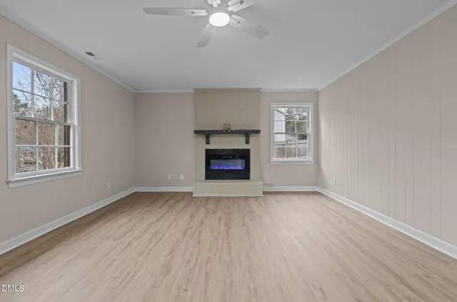 an empty room with windows and a fireplace