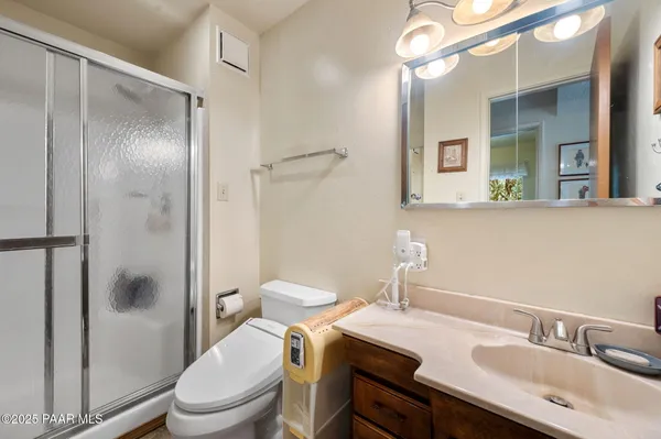 a bathroom with a granite countertop sink toilet a mirror and shower