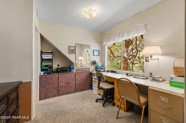 a view of a workspace with furniture and window