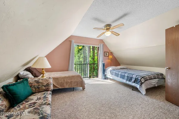 a bedroom with a bed lamp and a large window