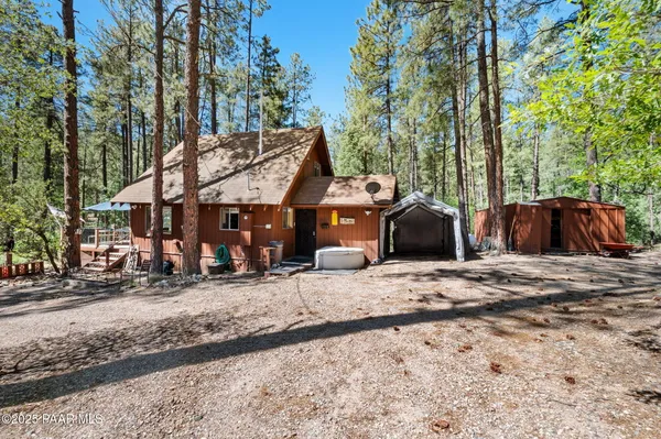 a view of a house with backyard and trees