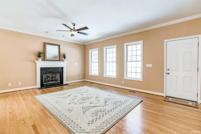 an empty room with windows and fireplace