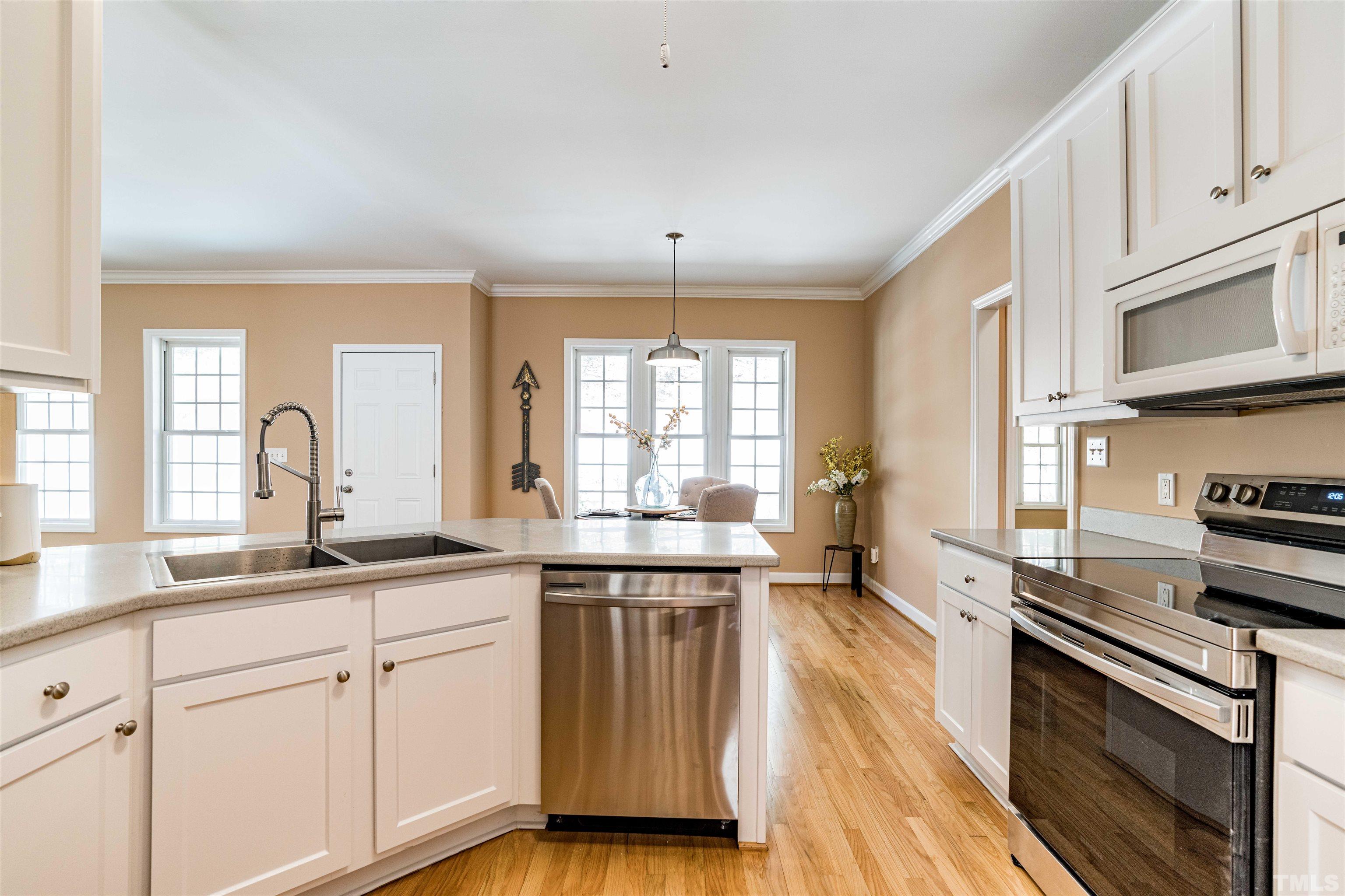 114 Marin Drive Chapel Hill, NC 27516 - Photo 12 of 27 a kitchen with stainless steel appliances granite countertop a stove a sink and white cabinets