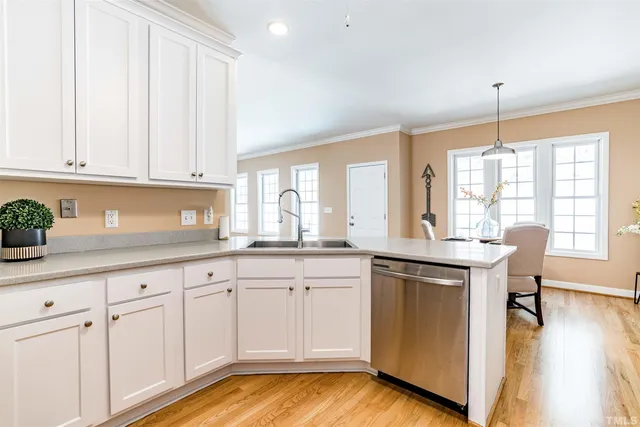 a kitchen with white cabinets and sink