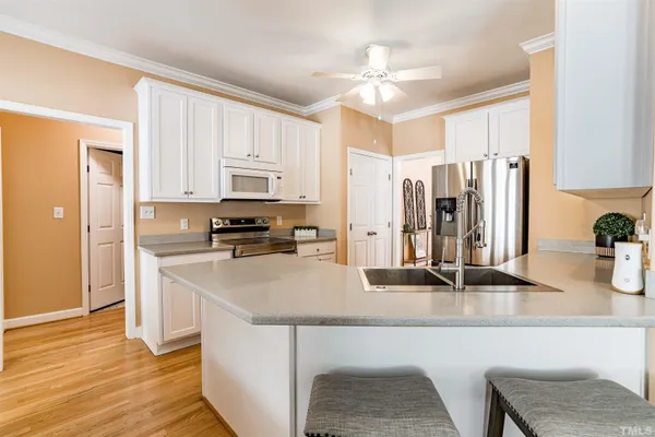 a kitchen with stainless steel appliances granite countertop a sink refrigerator and cabinets