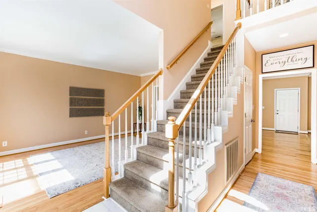 a view of staircase with lots of frames on wall and wooden floor