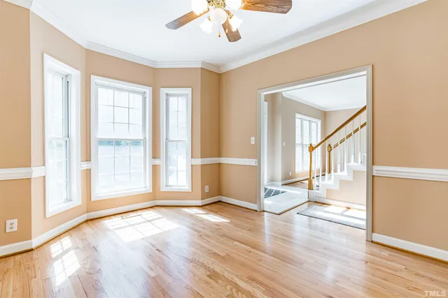 a view of a livingroom with wooden floor and a ceiling fan