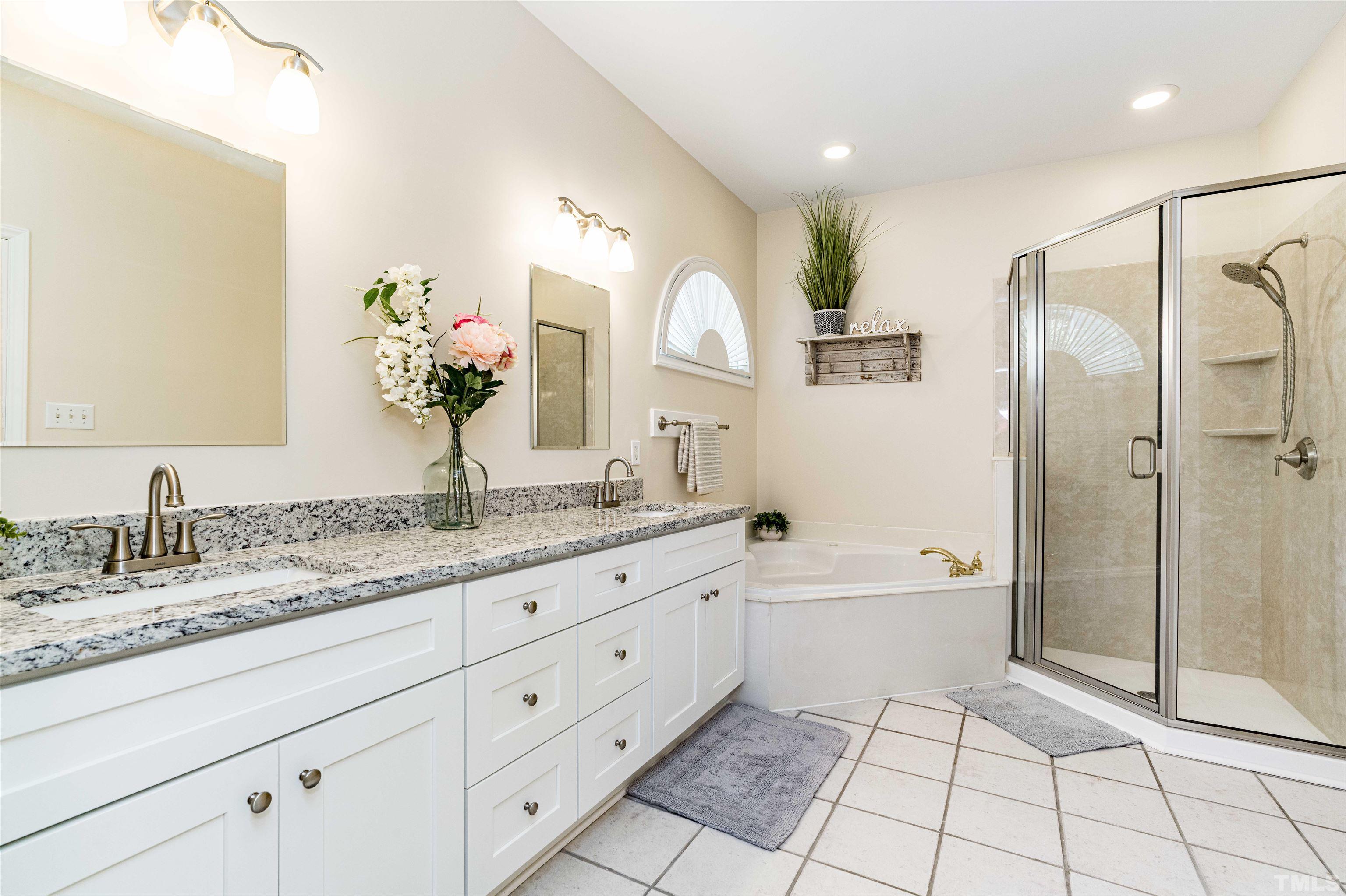 114 Marin Drive Chapel Hill, NC 27516 - Photo 24 of 27 a spacious bathroom with a granite countertop sink mirror and a bathtub