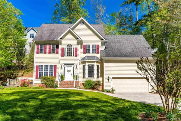 a front view of a house with a yard and trees