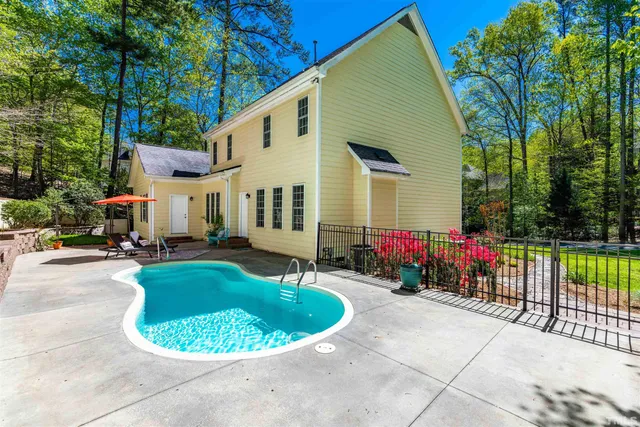 a view of a house with backyard sitting area and swimming pool