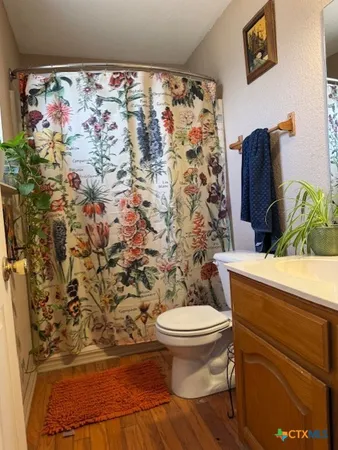 a bathroom with a toilet and a shower curtain