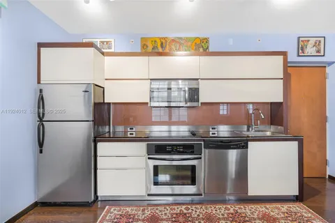 a kitchen with stainless steel appliances granite countertop a refrigerator sink stove and cabinets