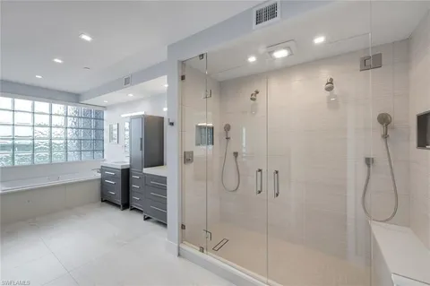 a bathroom with a double vanity sink mirror and shower