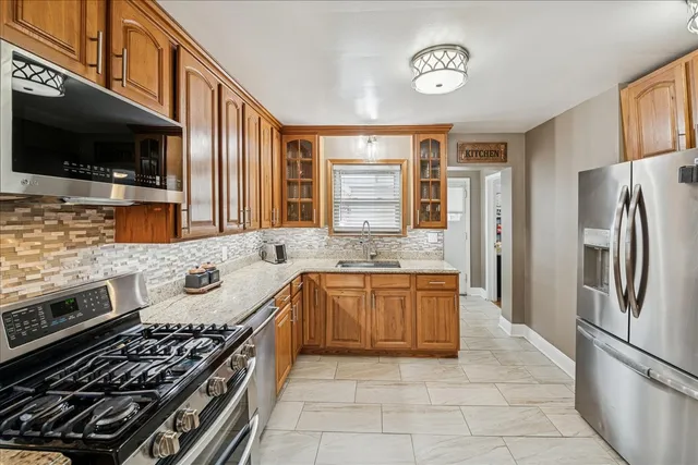a kitchen with stainless steel appliances granite countertop a refrigerator oven a sink and dishwasher