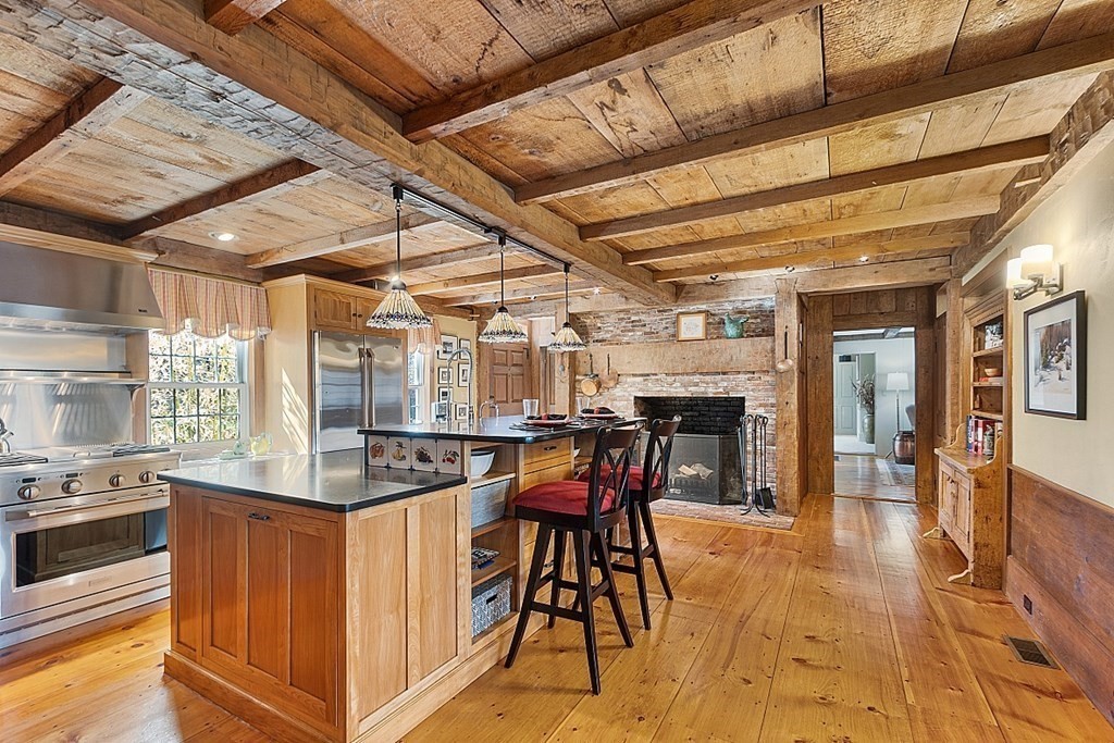 65 Lawrence Road Boxford, MA 01921 - Photo 4 of 36 a kitchen with stainless steel appliances granite countertop a table chairs and wooden floors