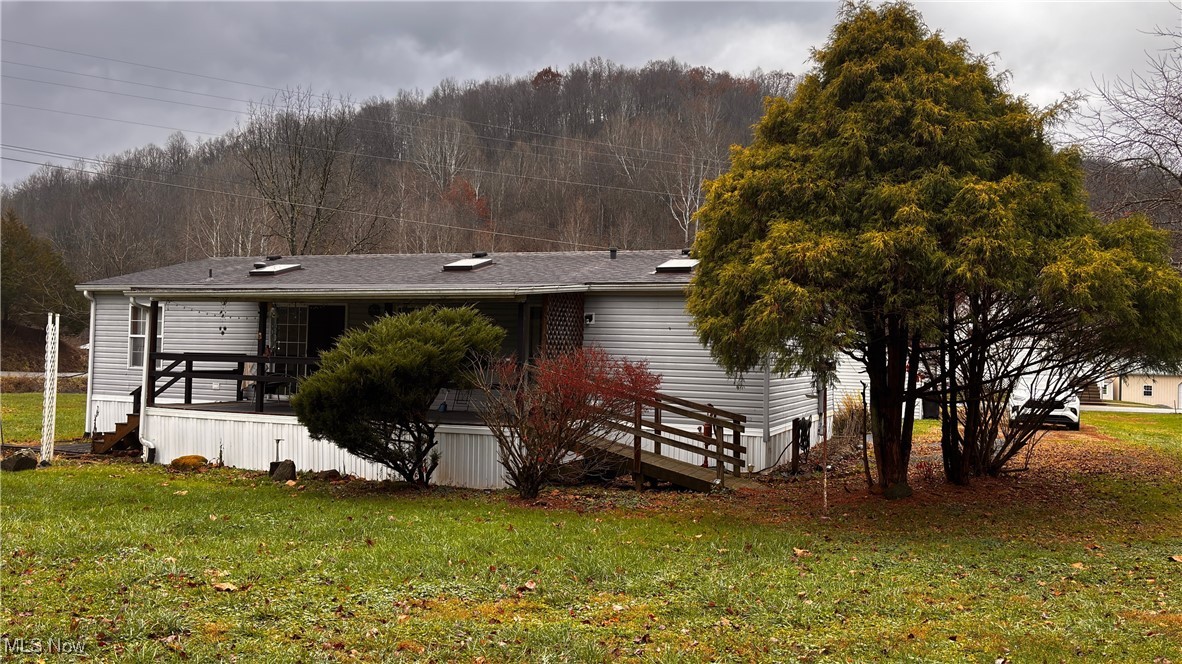 2090 Big Flint Road Salem, WV 26426 - Photo 5 of 22 Rear view of house featuring a lawn, a deck, roof with shingles, and a view of trees