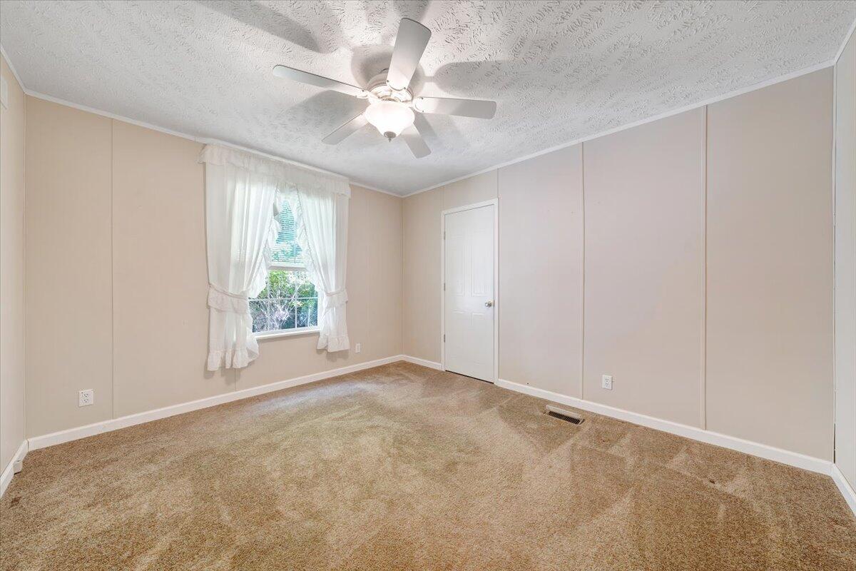 460 White Oak Road Boones Mill, VA 24065 - Photo 20 of 45 an empty room with windows and chandelier fan
