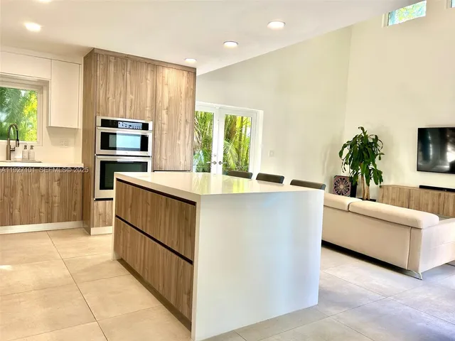 a kitchen with kitchen island white cabinets and stainless steel appliances
