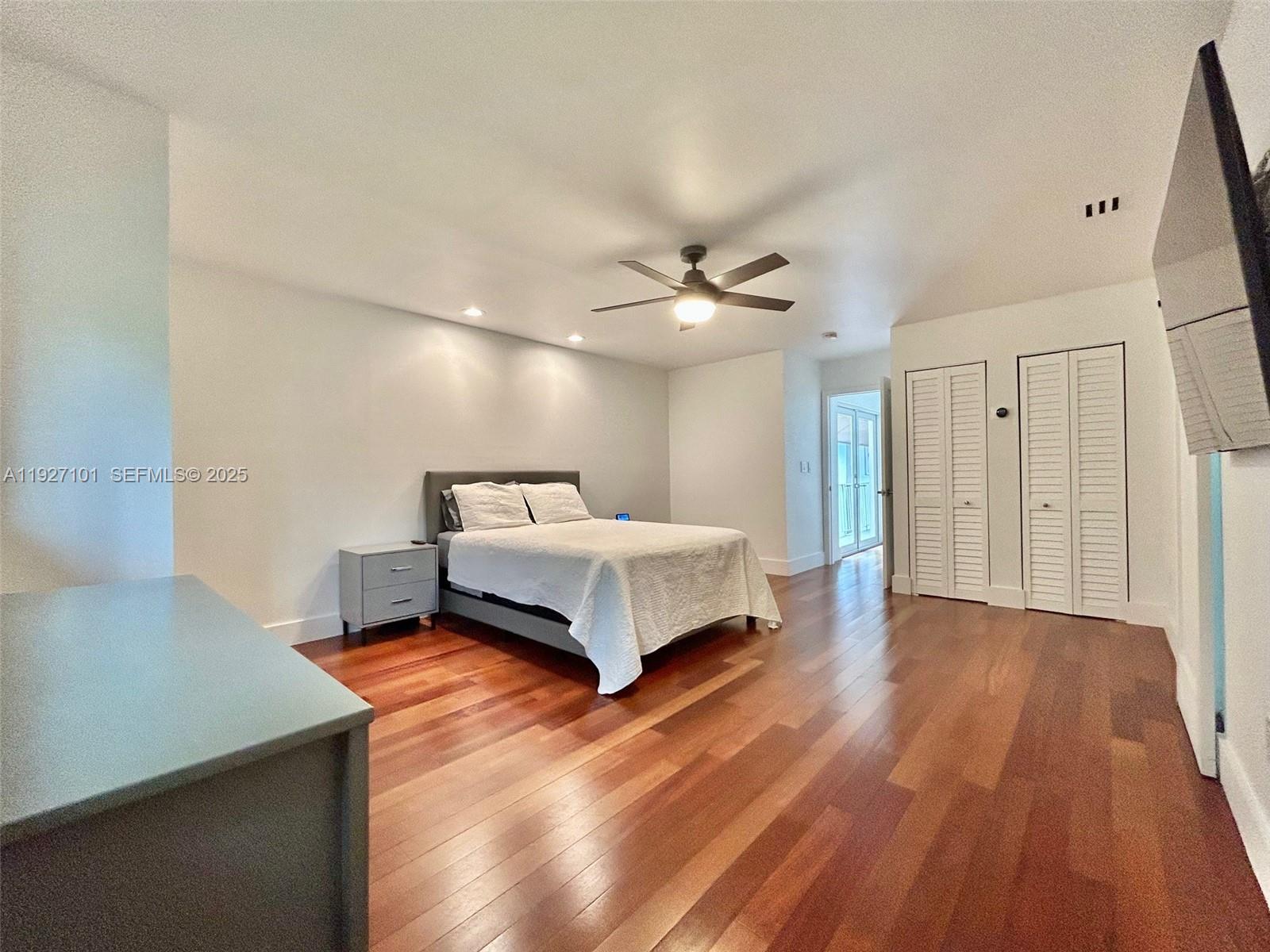 4445 Red Road Coral Gables, FL 33146 - Photo 32 of 41 a spacious bedroom with a bed and a chandelier