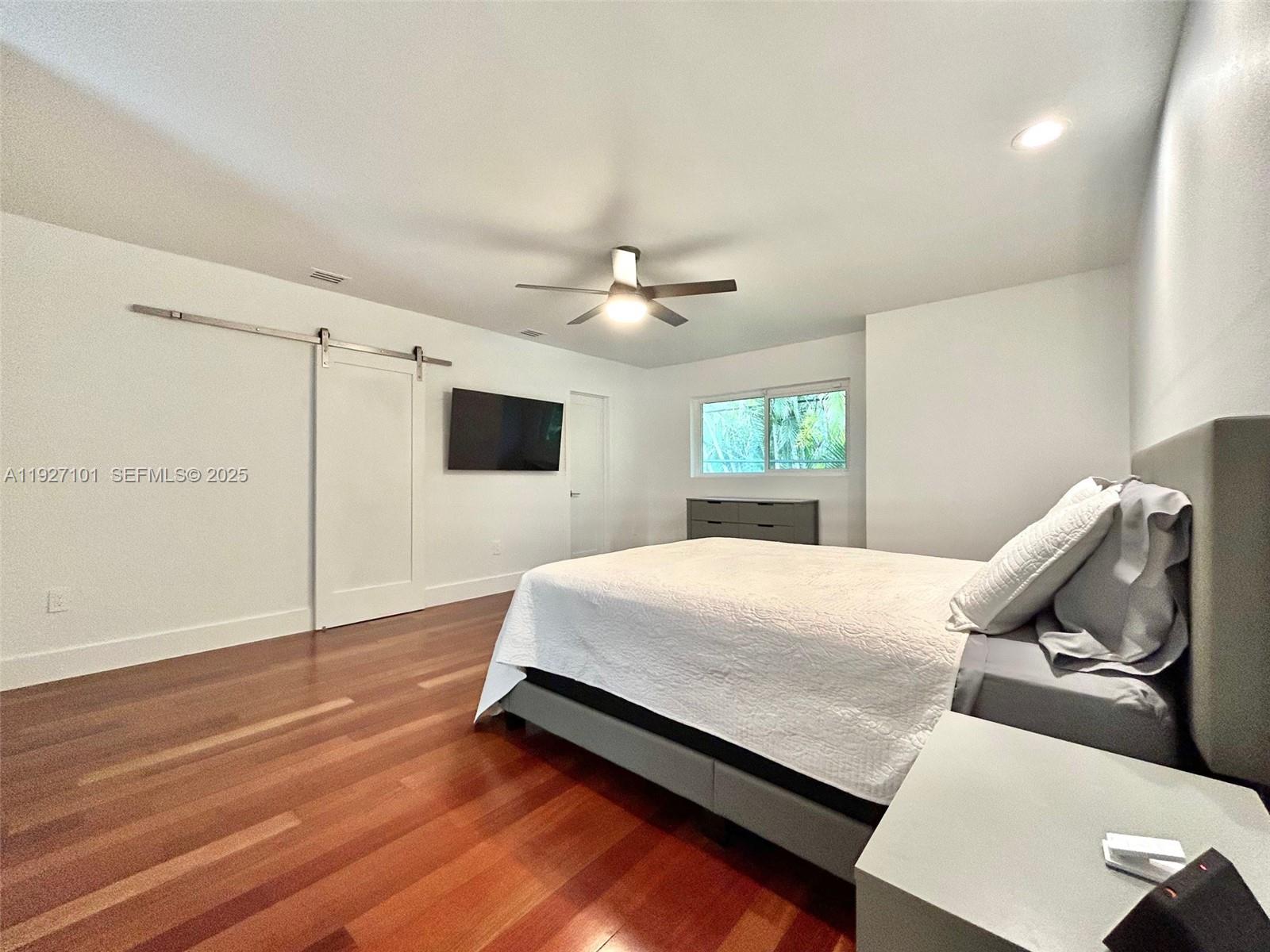 4445 Red Road Coral Gables, FL 33146 - Photo 33 of 41 a spacious bedroom with a bed and a flat screen tv