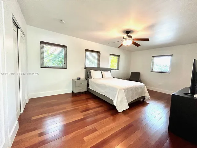 a bedroom with a bed and wooden floor