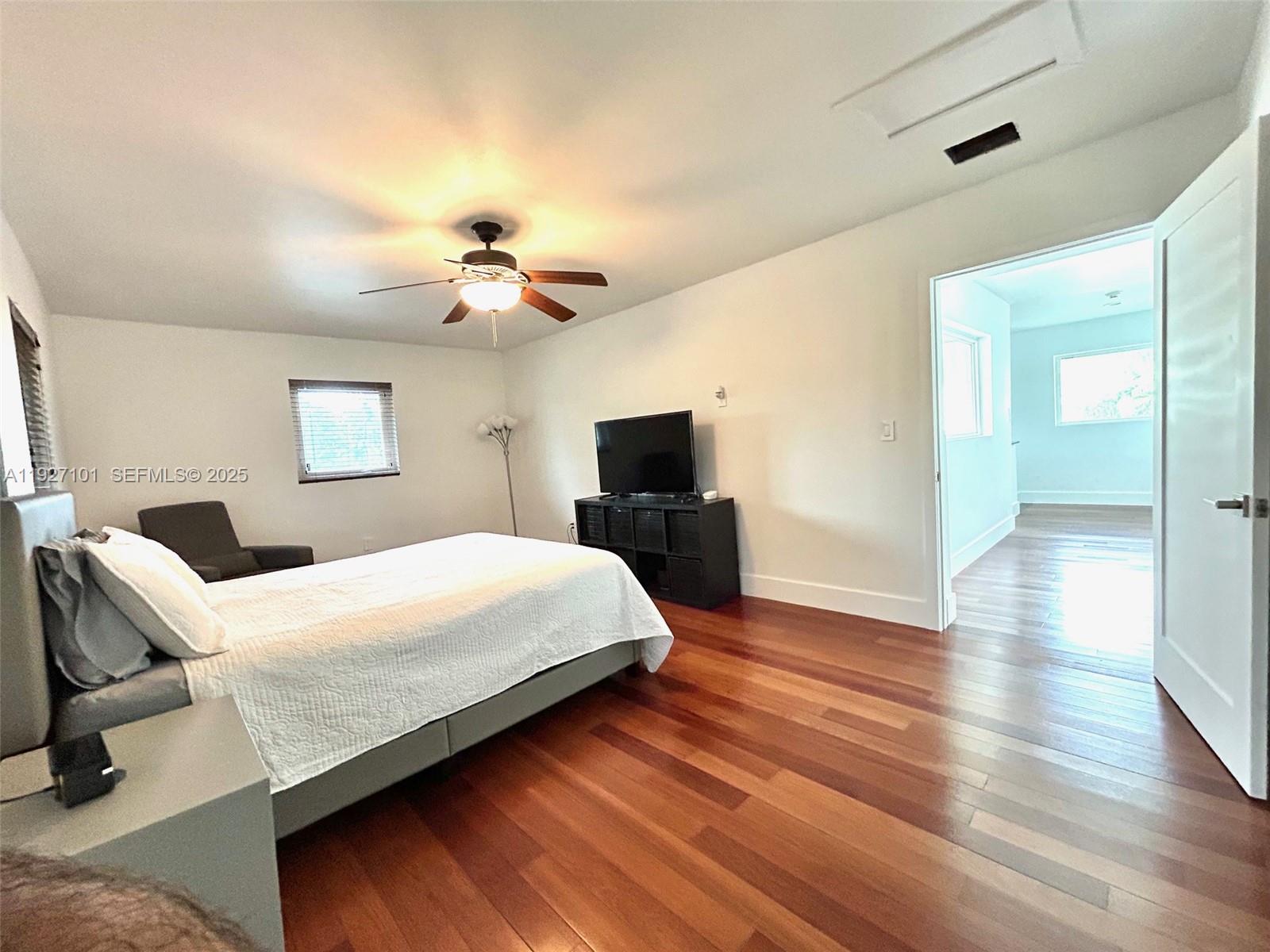 4445 Red Road Coral Gables, FL 33146 - Photo 37 of 41 a spacious bedroom with a bed and a chandelier